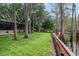 A spacious backyard with mature trees and a screened-in patio overlooking the lake at 3428 Valley Ranch Dr, Lutz, FL 33548