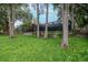 A well-maintained backyard with mature trees, a screen enclosure, and a charming backyard at 3428 Valley Ranch Dr, Lutz, FL 33548