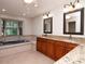 Bright bathroom with a soaking tub, double vanity, and a large window at 3428 Valley Ranch Dr, Lutz, FL 33548