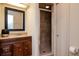 Bathroom vanity with wood cabinets, granite counter, framed mirror and tile shower with glass door at 3428 Valley Ranch Dr, Lutz, FL 33548