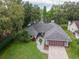 Beautiful home featuring a well-maintained lawn, mature trees, and a brick driveway leading to an attached two-car garage at 3428 Valley Ranch Dr, Lutz, FL 33548