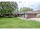 Charming single-story home with well-manicured lawn, mature trees, and an attached two-car garage at 3428 Valley Ranch Dr, Lutz, FL 33548