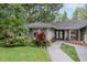 Close up of gray home with elegant landscaping, walkway, and double-door front entrance at 3428 Valley Ranch Dr, Lutz, FL 33548
