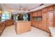 Open concept kitchen with central island, granite counters, wood cabinets and stainless fridge at 3428 Valley Ranch Dr, Lutz, FL 33548
