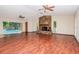 Spacious living room with fireplace, hardwood floors, and access to the screened-in pool at 3428 Valley Ranch Dr, Lutz, FL 33548
