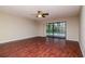 Spacious living room with hardwood floors, ceiling fan, and sliding glass doors overlooking the pool at 3428 Valley Ranch Dr, Lutz, FL 33548