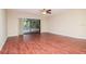 Spacious living room with hardwood floors, ceiling fan, and sliding glass doors leading to pool at 3428 Valley Ranch Dr, Lutz, FL 33548