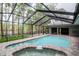 Screened in pool area with jacuzzi and view of the lake at 3428 Valley Ranch Dr, Lutz, FL 33548