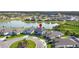Aerial view of a neighborhood featuring a home with well-manicured lawn near a tranquil lake at 34307 Radley Way, Wesley Chapel, FL 33545