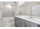 Elegant bathroom featuring a double vanity, granite countertops, and decorative backsplash in shower at 34307 Radley Way, Wesley Chapel, FL 33545