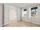 Bright bedroom featuring neutral walls, wood floors, and two large windows with views of the outdoors at 34307 Radley Way, Wesley Chapel, FL 33545