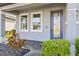 Inviting front porch with a decorative glass door, well-manicured shrubs, and stone accents at 34307 Radley Way, Wesley Chapel, FL 33545