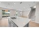 Kitchen with an island, sleek countertops, stainless steel appliances, and an adjacent staircase at 34307 Radley Way, Wesley Chapel, FL 33545