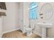 Stylish powder room with modern vanity and a well-lit round mirror, shelves and a window at 34307 Radley Way, Wesley Chapel, FL 33545