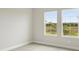Bright bedroom features neutral walls and carpet with two windows offering natural light and outdoor views at 3818 Farm Garden Ct, Lakewood Ranch, FL 34211