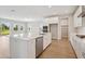 Modern kitchen featuring white cabinets, stainless appliances, a spacious island and wood flooring at 3818 Farm Garden Ct, Lakewood Ranch, FL 34211