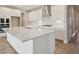 Bright kitchen with white cabinetry, stainless steel appliances, and a large quartz island at 3818 Farm Garden Ct, Lakewood Ranch, FL 34211