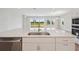 Modern kitchen island with stainless steel dishwasher, undermount sink, and faucet overlooking the dining area at 3818 Farm Garden Ct, Lakewood Ranch, FL 34211