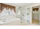 Bathroom featuring a marble shower, soaking tub and a window with attractive curtains at 4224 Fleewell Ct, Valrico, FL 33596