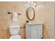 A bathroom with a white vanity, a toilet, decorative wall tiles and an oval mirror at 5015 15Th S Ave, Gulfport, FL 33707