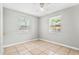 Bright, neutral bedroom with tile floors, fan, and natural light from two windows at 5015 15Th S Ave, Gulfport, FL 33707