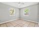 Neutral bedroom with tile flooring, ceiling fan, and natural light from two windows at 5015 15Th S Ave, Gulfport, FL 33707