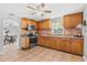 A view of the kitchen featuring wooden cabinets, a window, a ceiling fan, and tiled floors at 5015 15Th S Ave, Gulfport, FL 33707