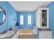 Bright bathroom featuring a soaking tub, single vanity, ample storage, and bright blue walls at 520 Canal Way, Oldsmar, FL 34677