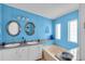 Comfortable bathroom with double sinks, vanity, soaking tub and bright blue walls at 520 Canal Way, Oldsmar, FL 34677