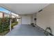 Covered carport featuring a garage, entrance door, and room for parking with garden backdrop at 520 Canal Way, Oldsmar, FL 34677