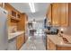 Galley-style kitchen with stainless appliances, warm wood cabinets, and an adjacent dining area with backyard view at 520 Canal Way, Oldsmar, FL 34677