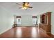 Spacious living room featuring wood floors, large windows, ceiling fan and classic wood hutch at 520 Canal Way, Oldsmar, FL 34677