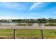 A serene water view is seen from the property overlooking lush greenery and distant homes on a clear sunny day at 520 Canal Way, Oldsmar, FL 34677