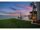 Beautiful waterfront backyard featuring a pool, lounge chairs, and gorgeous sunset views at 5810 Mariner St, Tampa, FL 33609