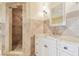 Bathroom featuring white cabinets, granite countertops, updated fixtures, and a walk-in shower with tile at 5810 Mariner St, Tampa, FL 33609