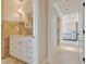 Half bathroom with marble countertops, a decorative mirror, and a hallway view leading to a bedroom at 5810 Mariner St, Tampa, FL 33609