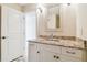 Bathroom featuring granite countertops, white cabinetry, updated fixtures and a view of the walk in shower at 5810 Mariner St, Tampa, FL 33609