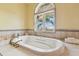 Luxurious soaking tub set against a large window, offering serene outdoor views at 5810 Mariner St, Tampa, FL 33609