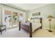 A light and airy bedroom with balcony access and views of tropical foliage and blue waters at 5810 Mariner St, Tampa, FL 33609