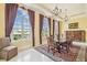 Elegant dining room with a large window, a decorative chandelier, and dark red curtains at 5810 Mariner St, Tampa, FL 33609