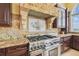 Close up of professional grade KitchenAid oven, granite countertop, and mosaic accents at 5810 Mariner St, Tampa, FL 33609