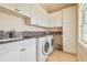 Well-lit laundry room with granite countertops, ample cabinet space, and modern washer/dryer at 5810 Mariner St, Tampa, FL 33609