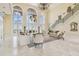 Bright living room with staircase, chandelier, and large windows that frame beautiful water views at 5810 Mariner St, Tampa, FL 33609