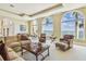 Elegant living room with comfortable seating arrangements, multiple arched windows, and serene waterfront views at 5810 Mariner St, Tampa, FL 33609