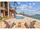 Waterfront backyard featuring an outdoor swimming pool, patio with lounge chairs, and ocean views at 5810 Mariner St, Tampa, FL 33609
