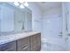 Well-lit bathroom with granite countertops, dark wood cabinets, and shower-tub combination at 5933 Caldera Ridge Dr, Lithia, FL 33547