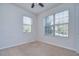 Bright, cozy bedroom featuring two large windows and neutral carpeting at 5933 Caldera Ridge Dr, Lithia, FL 33547