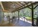 Relaxing covered patio with wood floors and outdoor seating overlooking a lush green space at 5933 Caldera Ridge Dr, Lithia, FL 33547