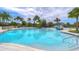Community pool with a splash area, lounge chairs, and lush tropical landscaping at 5933 Caldera Ridge Dr, Lithia, FL 33547