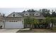 Charming two-story home with a well-maintained lawn, mature palm trees, and an attached two-car garage at 6213 Crickethollow Dr, Riverview, FL 33578
